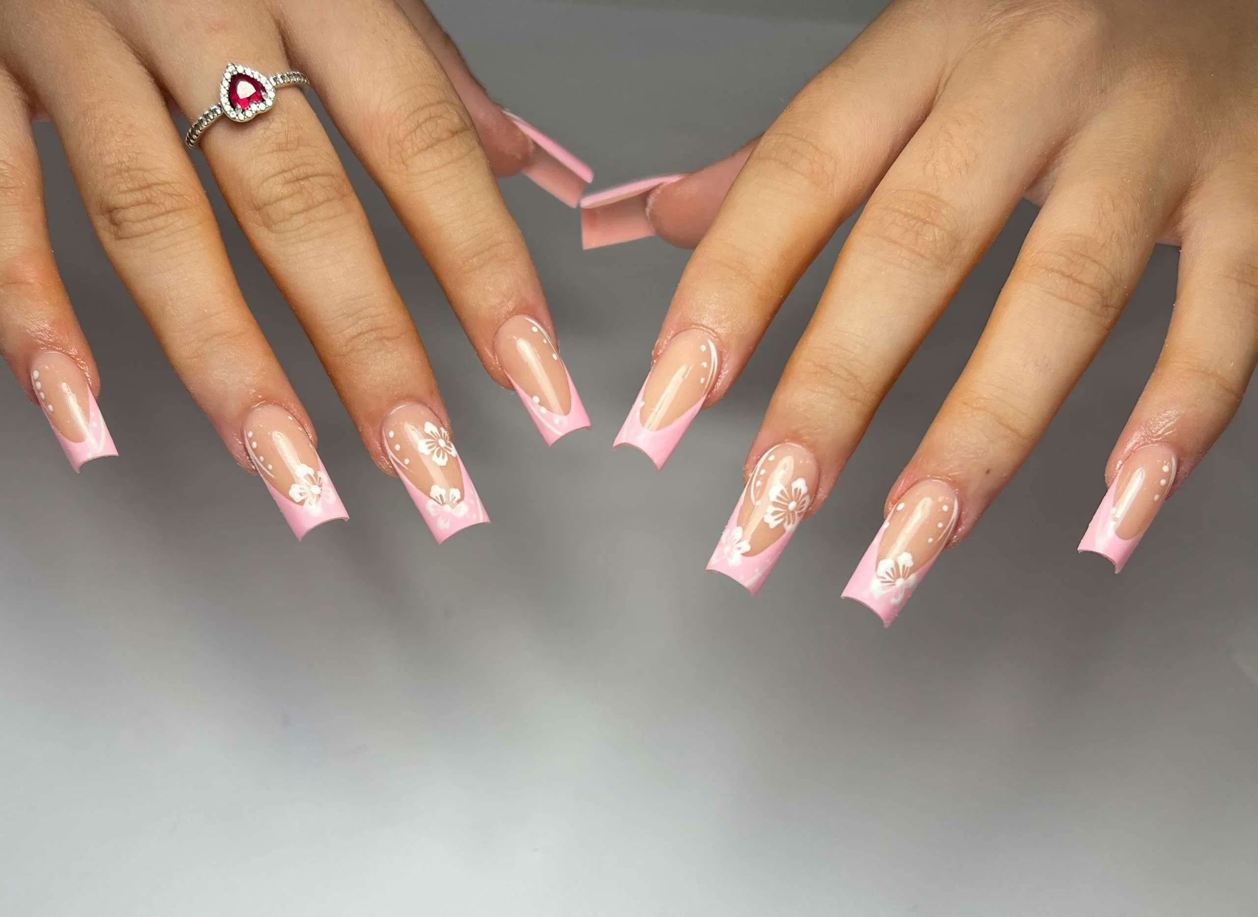 Pink nails with delicate floral nail art at Aurevia Nails